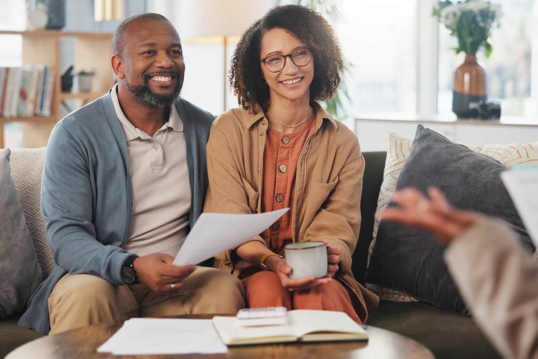 A middle-aged couple talking to a real estate professional during a consultation.